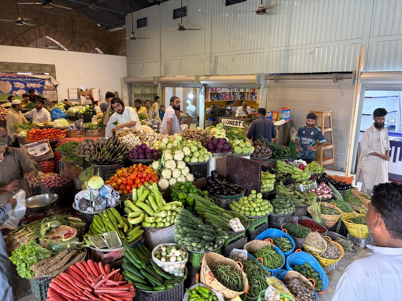 Fresh produce hall inside Empress Market with vendors and shoppers